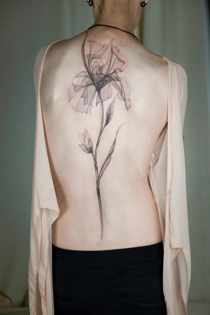 Subtelny tatuaż kwiatowy fineline wykonany na plecach w studiu w Częstochowie