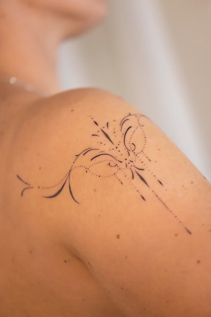 Subtelny tatuaż ornamentalny na ramieniu przypominający biżuterię – studio Częstochowa
