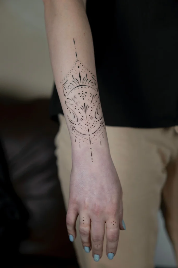 Szczegółowy kobiecy tatuaż ornamentalny na przedramieniu łączący precyzyjne linie fineline i subtelny dotwork (kropki). Wykonanie: Wika Olejnik, Częstochowa.
