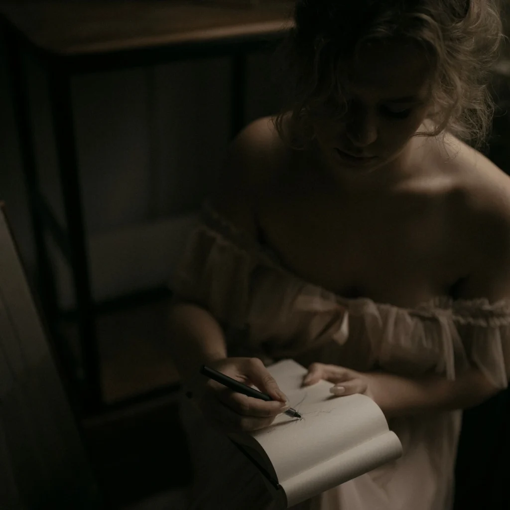 Wiktoria Olejnik rysująca szkic tatuażu w notesie – proces twórczy w Olejnik Tattoo.