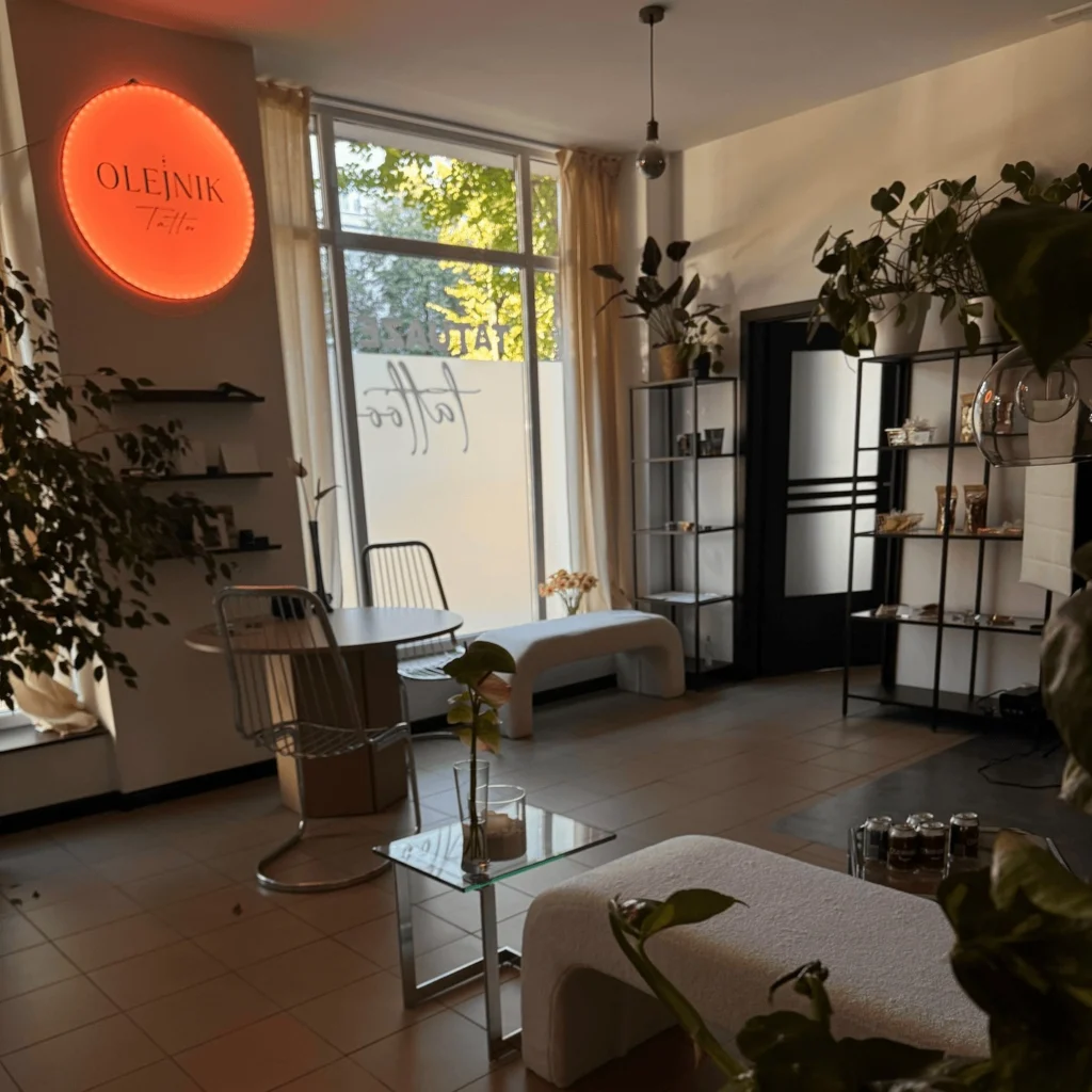 Nowoczesne i stylowe wnętrze studia tatuażu Olejnik Tattoo w Częstochowie. Widoczna strefa klienta i charakterystyczny neon.